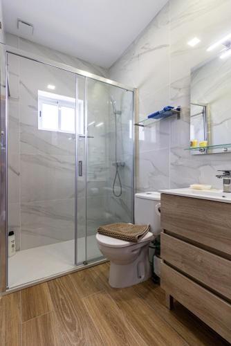a bathroom with a shower and a toilet and a sink at Guest H4U - Garden & Beach Mindelo in Mindelo