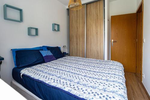 a bedroom with a bed with a blue comforter at Guest H4U - Garden & Beach Mindelo in Mindelo