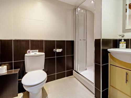 a bathroom with a toilet and a shower and a sink at 1 Bed in Doncaster oc-93769 in Mattersey