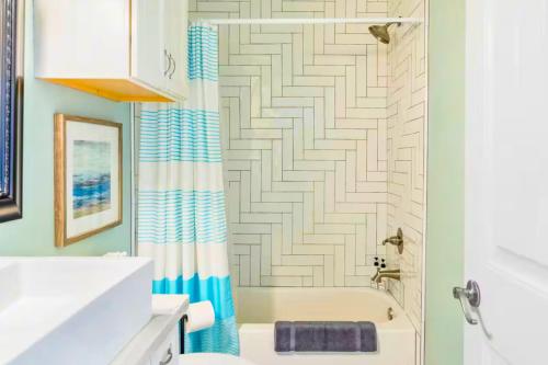 a bathroom with a tub and a shower curtain at 4BR Near the BeachFire PitFamily Friendly Stay in Bolivar Peninsula