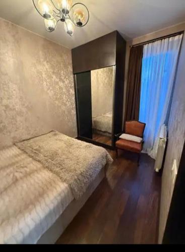 a bedroom with a bed and a mirror and a chair at Cozy Corner in Tbilisi City