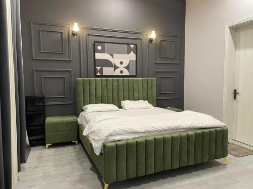 a bedroom with a green bed in a room at ASNB Farm House 2BHK with Pool in Multan
