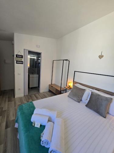 a bedroom with a large bed with towels on it at Sol da Praia in Odeceixe