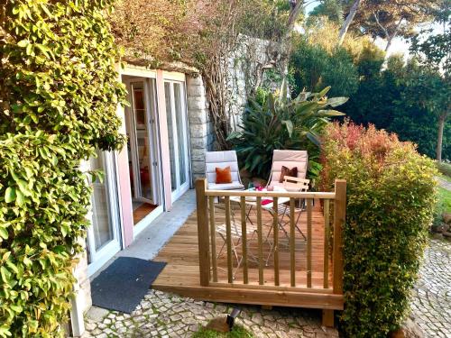 a wooden deck with two boxes on it at Quiet Studio with garden 8 Min from Beach in Estoril