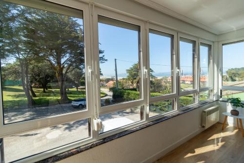 a room with windows with a view of a street at Bahía Dorada Loredo - 3 hab, Terraza y Vistas al Mar in Loredo