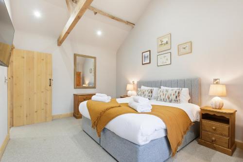 a bedroom with a large bed and a mirror at The Saddlery in Norwich