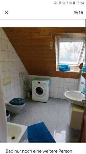 a bathroom with a toilet a sink and a microwave at Auerandstudio in Nienhagen