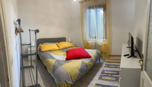 a bedroom with a bed with colorful pillows on it at Casa Neva in Cannobio