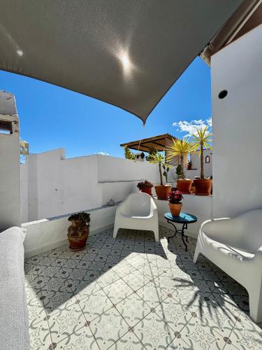 a patio with two chairs and a table at Casa Maroma in Cómpeta