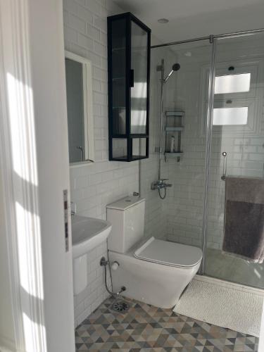 a bathroom with a toilet and a sink and a shower at Modern chic rooftop studio in Sheikh Zayed