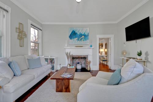 a living room with two white couches and a coffee table at Savannah Suite on Front in Wilmington
