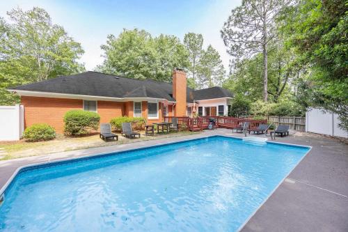 a home with a swimming pool in front of a house at Market District Pool House in Statesboro