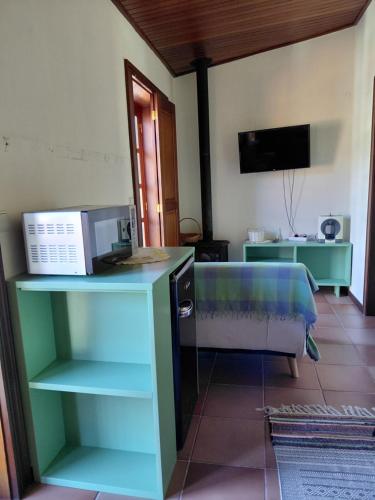 a living room with a microwave on a counter at Meus Rios - moradia T1 entre o Douro e Tâmega in Torrão