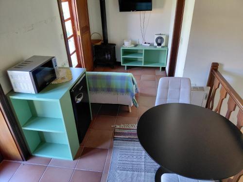 a living room with a table and a tv at Meus Rios - moradia T1 entre o Douro e Tâmega in Torrão