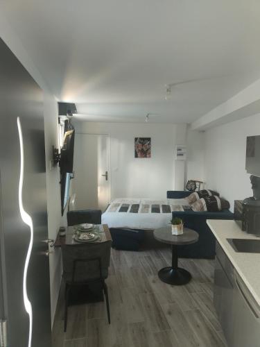 a living room with a bed and a table at Chez Olga studio indépendant in Giberville