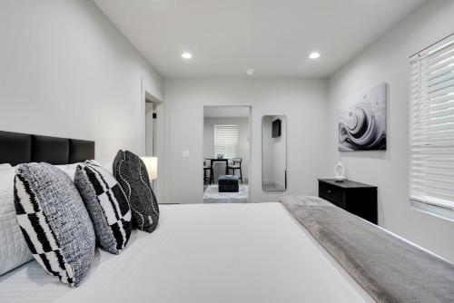 a white bedroom with a large bed with pillows at The Pearl Stylish Couples Getaway in Wilmington