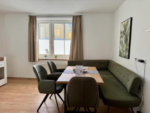 a living room with a couch and a table and chairs at Komfortables Innenstadt-Apartment WOLF - Zentrumlage in Sankt Pölten