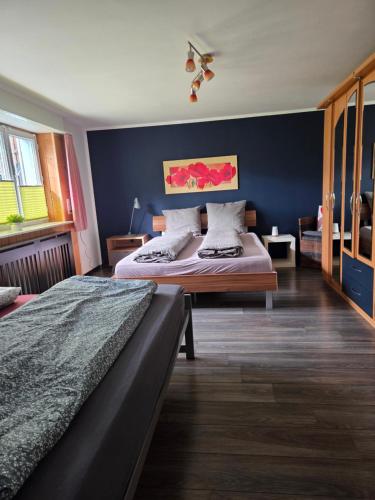 a bedroom with two beds and a blue wall at Ferienwohnung FeWe Wandern und Skifahren in Triesen