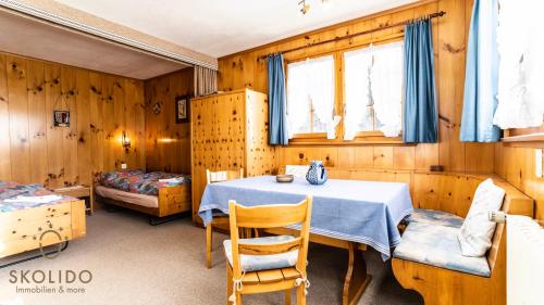 a dining room with a table and a bed at Haus Chämihitta, Riederalp Moosfluh in Riederalp