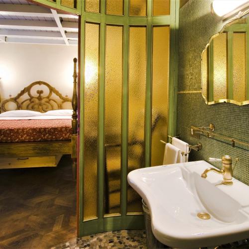 a bathroom with a sink and a bed at Locanda Amerigo in Savigno