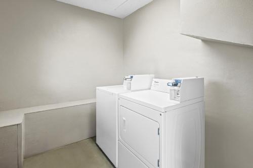 a white laundry room with a small white refrigerator at Super 8 by Wyndham Kingsport /I-81 in Kingsport