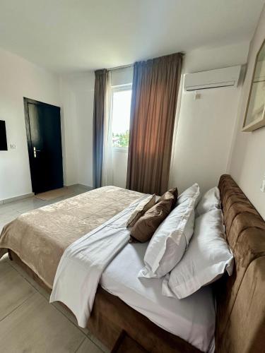 a bedroom with a large bed with pillows and a window at Nahé Résidence Deux Plateaux in Abidjan
