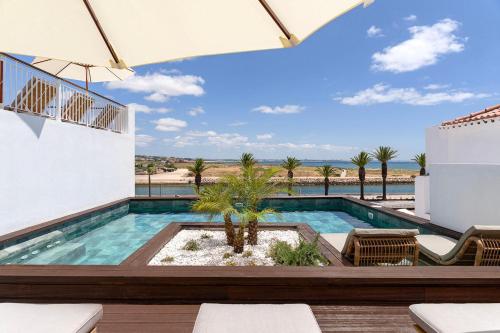 a swimming pool with a view of the ocean at Água Hotels Lagos Bay in Lagos