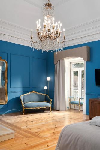 a blue bedroom with a couch and a chandelier at Água Hotels Lagos Bay in Lagos