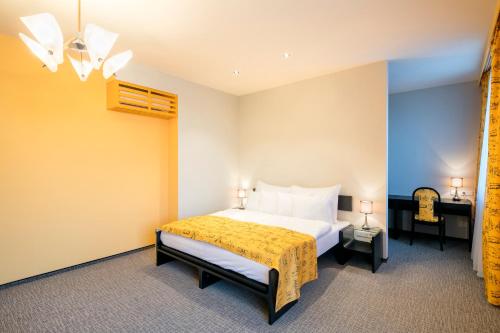 a bedroom with a bed with a yellow blanket at Pytloun Grand Hotel Imperial in Liberec