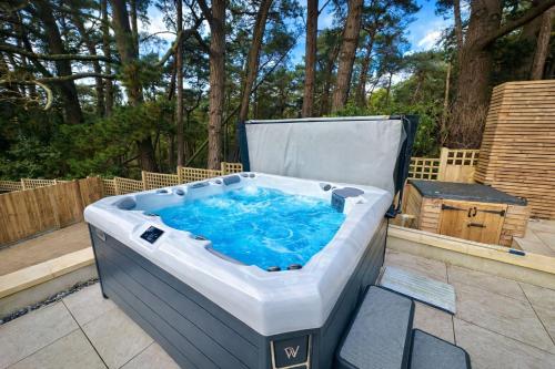a large hot tub sitting on a patio at 5 Bed House - Pool - Hot Tub - Sauna - Pool Table - Near New Forest and Beach - Sleeps 12 in Ringwood