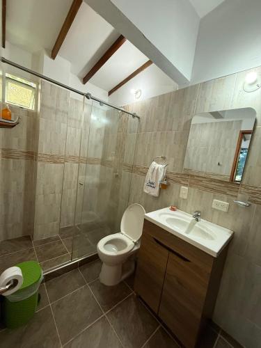 a bathroom with a toilet and a shower and a sink at Hotel Santorini Doradal in Doradal