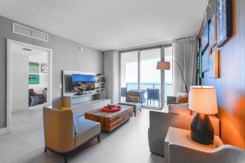 a living room with a couch and a tv at Hollywood Beach Luxury & Ocean Views in Hollywood