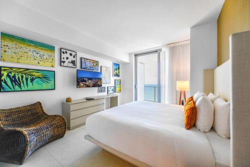 a bedroom with a large white bed and a chair at Hollywood Beach Luxury & Ocean Views in Hollywood