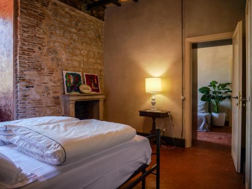 a bedroom with a bed and a brick wall at Red Palazzo Fossanova in Priverno