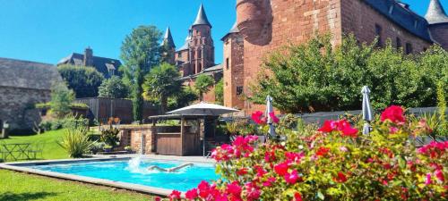 a house with a swimming pool in a yard with flowers at Château de Vassinhac chambres d'hôtes Collonges la rouge in Collonges