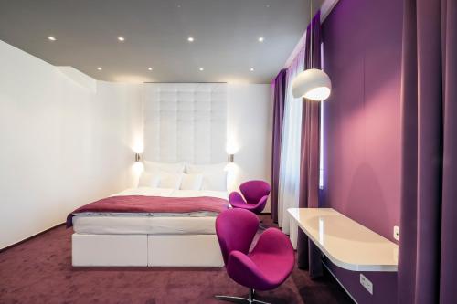 a bedroom with purple walls and purple chairs and a bed at Pytloun Grand Hotel Imperial in Liberec