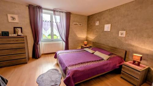 a bedroom with a purple bed and a window at Chez mamie couture in Bussière-Boffy