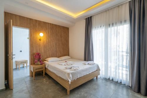 a bedroom with a bed and a large window at Orion hotel in Bodrum City