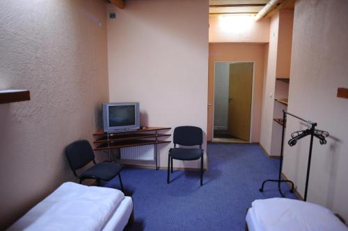 a room with two beds and a tv and two chairs at Perlyna Krasiyi in Vyshka