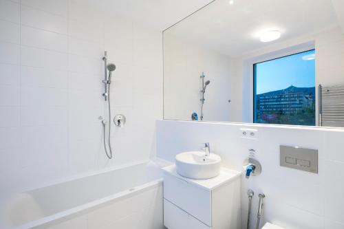 a white bathroom with a sink and a mirror at Pytloun Grand Hotel Imperial in Liberec