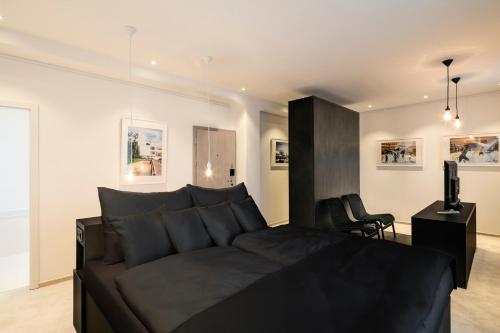 a bedroom with a black bed and a television at Pytloun Grand Hotel Imperial in Liberec