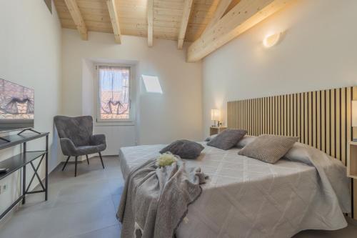 a bedroom with a large bed and a chair at Ca Magnolia Appartamento 3 in Lierna