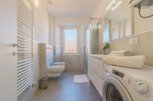a white bathroom with a washing machine in it at Ca Magnolia Appartamento 3 in Lierna