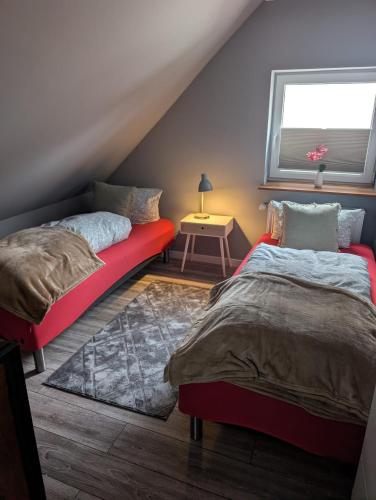 a bedroom with two beds and a red couch at Stadtnah an der Förde 57 01 in Flensburg