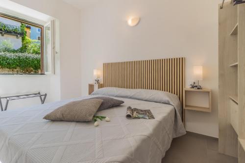 a bedroom with a bed with two pillows and a window at Ca Magnolia Appartamento 2 in Lierna