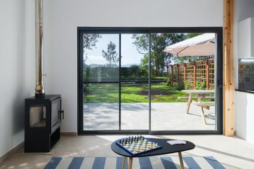 a room with a fireplace and a large window at FishTail Guest House in Rabo de Peixe