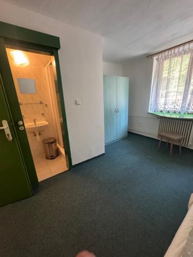 ein leerer Raum mit einer grünen Tür und einem Badezimmer in der Unterkunft Chata na Pile in Sedlice
