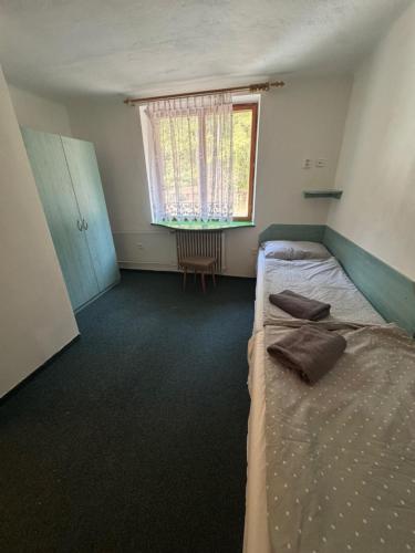 ein Schlafzimmer mit zwei Betten und einem Fenster in der Unterkunft Chata na Pile in Sedlice