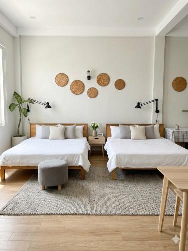 two beds in a bedroom with white walls at Kavy Homestay in Thôn Trường Giang