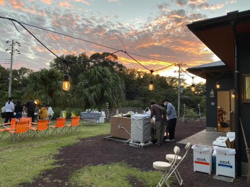 a group of people standing at a table at an event at Big Island Base 庭で過ごす少し特別な夜 一棟貸し 最大6名 in Oshima